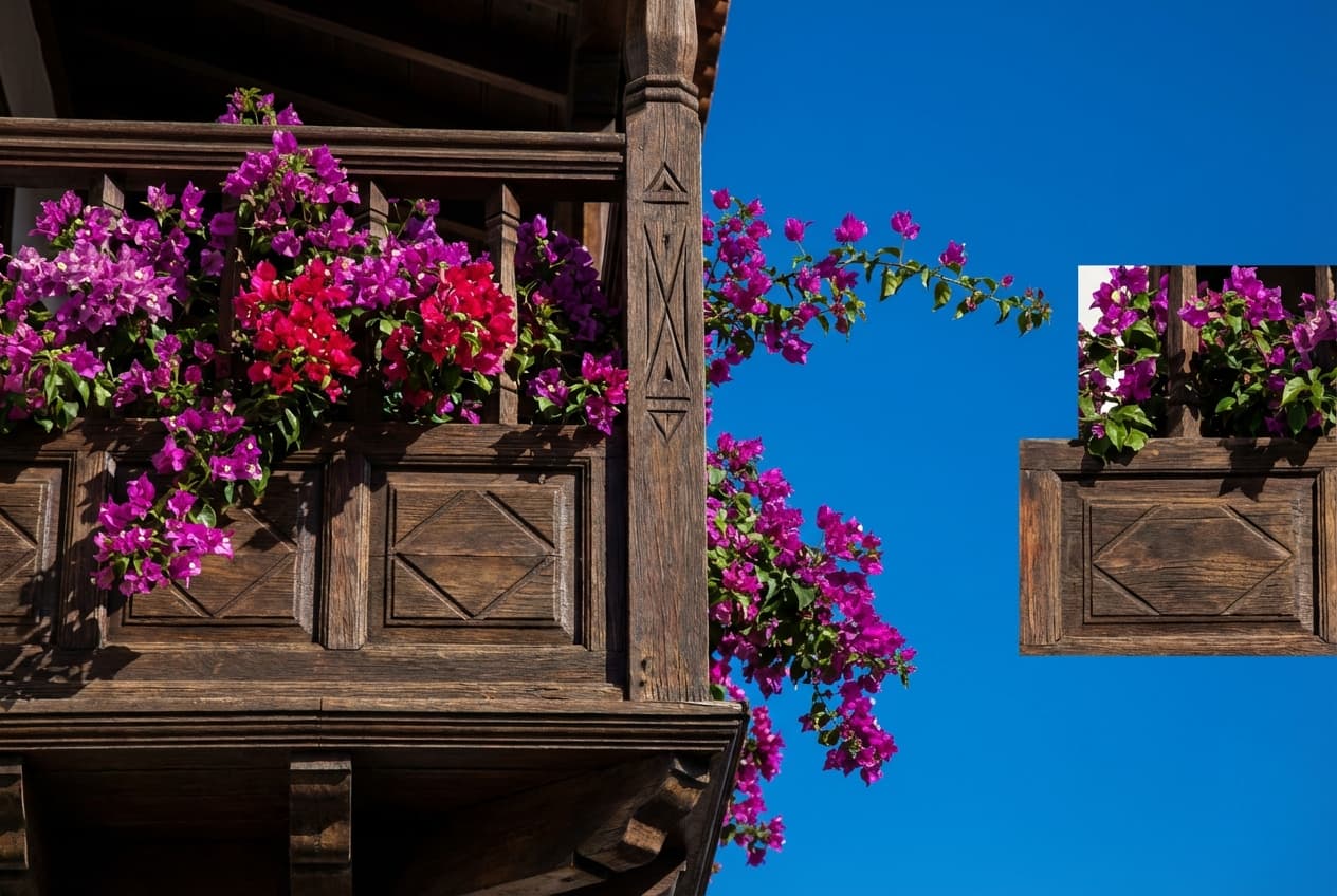 Détail iconique d'un balcon traditionnel canarien fleuri sur fond de ciel bleu.