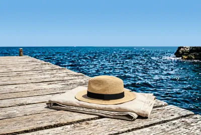 Accessoires de plage minimalistes sur un ponton en bois dans les Pouilles