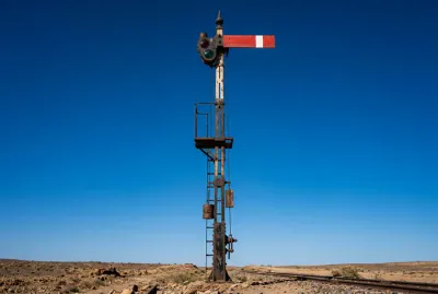 Signalisation ferroviaire minimaliste sur un ciel bleu profond, symbolisant le voyage