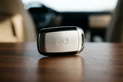 Gros plan sur une clé de camping-car moderne sur un tableau de bord en bois.