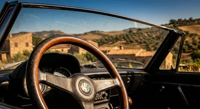 Gros plan iconique d'un volant de voiture devant un paysage sicilien ensoleillé