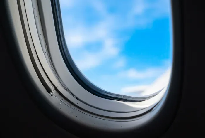 Vue depuis le hublot d'un avion avec un ciel bleu lumineux